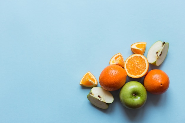 Photo fresh oranges and green apples on the blue background