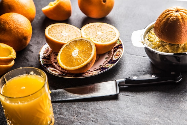 Photo fresh oranges juicer juice and tropical fruits on concrete board