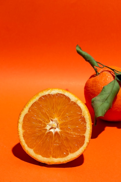 Фото Свежие апельсины на оранжевом фоне