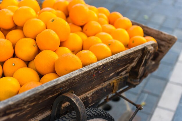 Fresh oranges on vintage wooden cart in the town