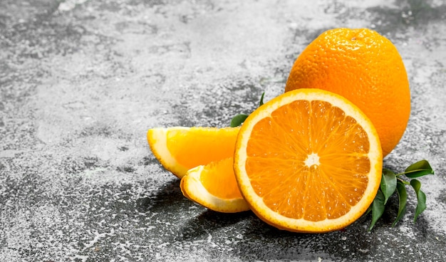 Fresh oranges with leaves on a rustic background