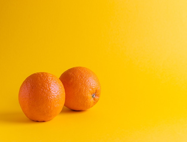 Fresh oranges on yellow background