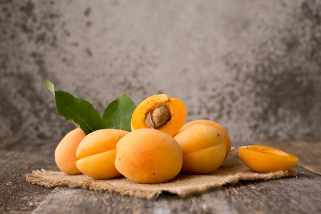 Fresh organic apricots with leaves on a wooden space