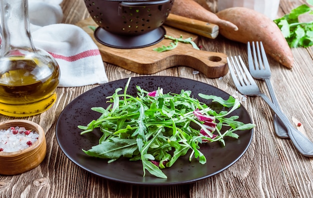 검은 접시에 신선한 유기농 arugula 잎