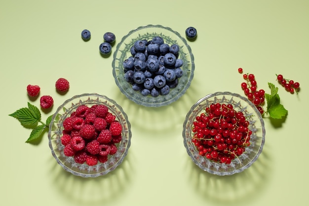 Photo fresh organic berries on green background with shadows detox and vitamin concept