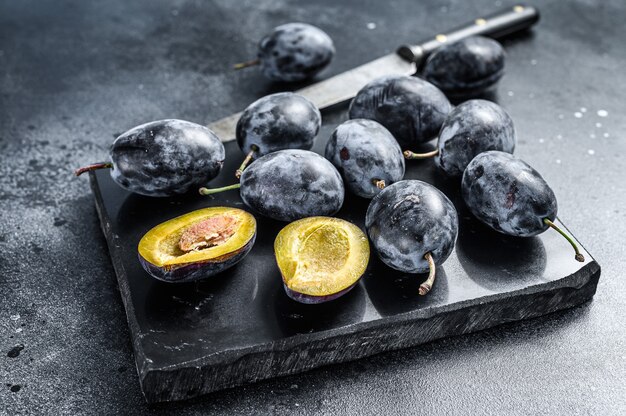 Fresh organic bio plums. Black background. Top view.