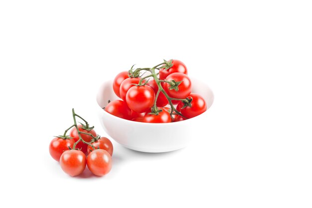 Fresh organic cherry tomatoes bunch on ceramic bowl.