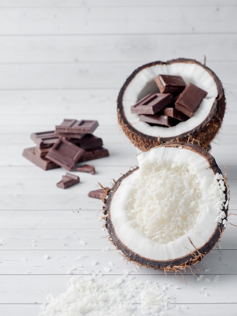 Свежий органический кокосовый орех, разделенный на две части с кокосовым орехом на деревенском деревянном фоне