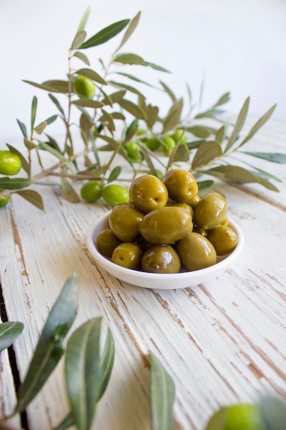 Fresh organic green olives on the white plate