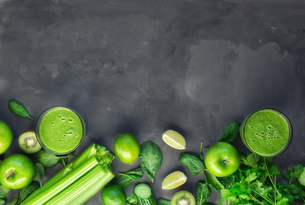 Fresh organic green smoothie with ingredients on gray concrete