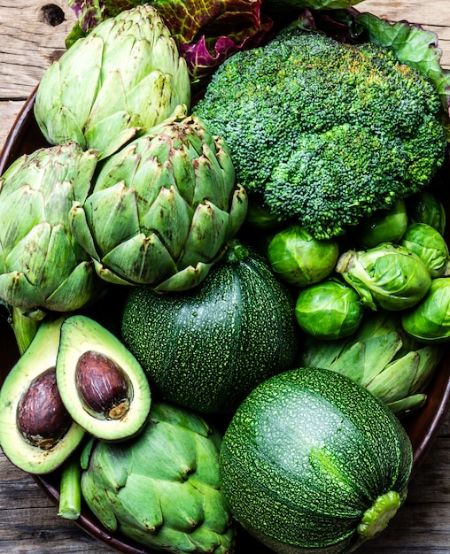 Fresh organic green vegetables in clay pot.