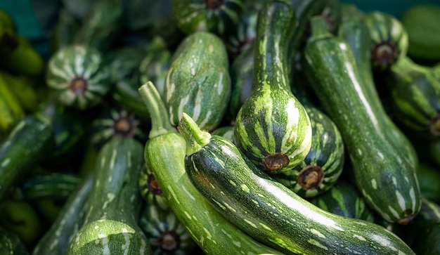 Fresh organic green zucchini on a market background Zucchini texture Lots of organic vegetables