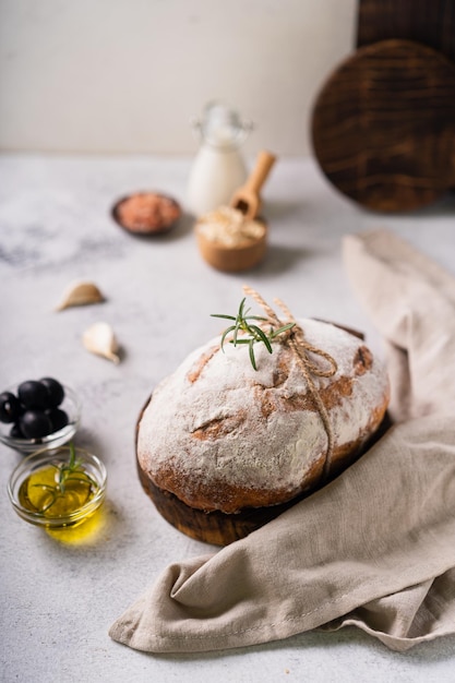 Свежий органический домашний ремесленный хлеб чиабатта с травами, оливковым маслом и оливками на белом деревенском фоне