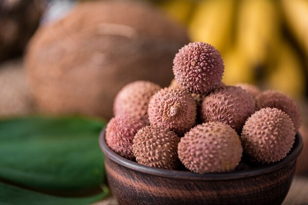 Fresh organic lychee fruit on bamboo basket and old wood background, Blurred background selective focus.