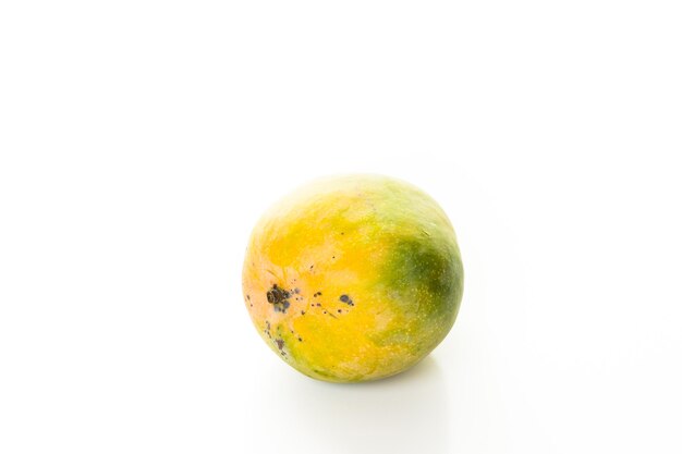 Fresh organic mango on a white wood board.