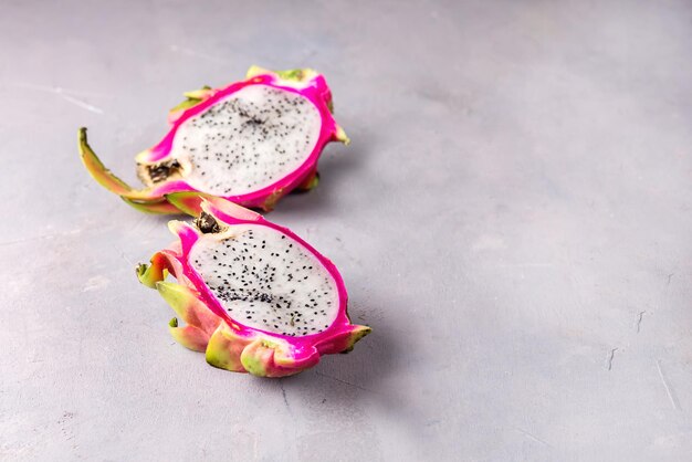 Fresh Organic Pitahaya Dragon Fruit Cut in Halves on Gray Background Tasty Tropical Fruit Copy Space