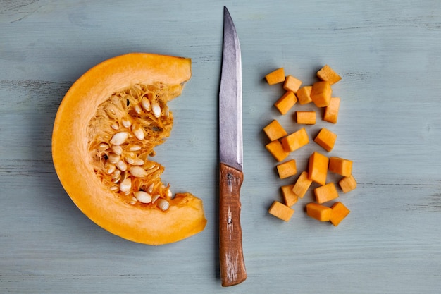 Fresh organic pumpkin slice and diced and old knife