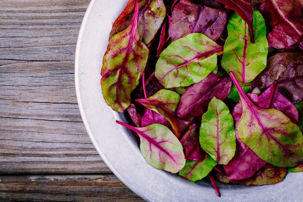 Fresh organic raw leaves of lettuce beets for salad on a wooden background Top view