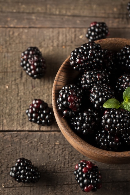 Fresh organic ripe blackberries in a wooden bowl 