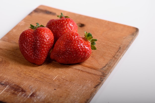 Fresh organic strawberries on a wooden board. Delivery of natural products. Packaging made from organic strawberries.