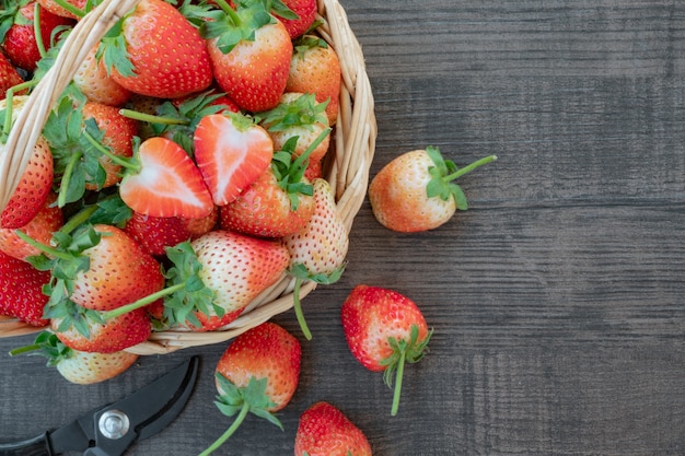 Photo fresh organic strawberry on basket. wooden background.