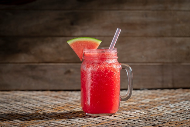 Fresh organic watermelon smoothie in glass mug on table, close up