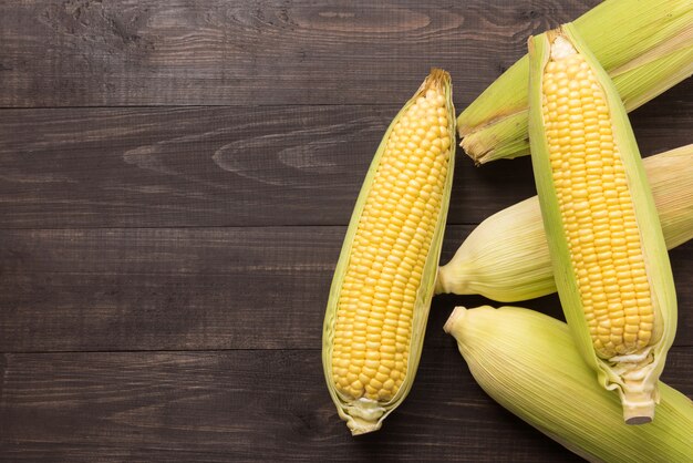 Fresh organic yellow sweet corn on wooden table. Top view