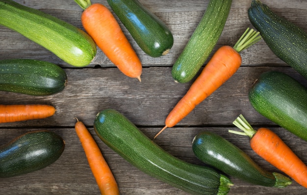 Zucchine e carote organiche fresche sulla tavola rustica. vista dall'alto