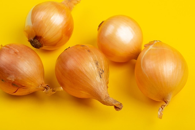 Fresh organis onions on yellow background Vegetables Healthy food concept