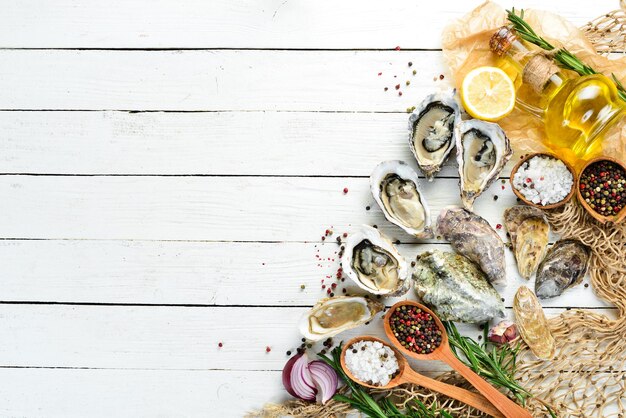 Photo fresh oyster with lemon. seafood. top view. on a white wooden background. free copy space.