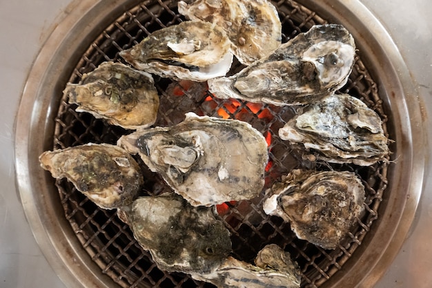 Fresh oysters on barbecue grill in a restaurant at Taiwan