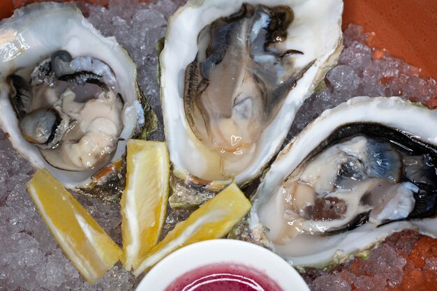 Fresh oysters in a bowl with ice lemon and sauce shellfish in the restaurant a luxurious healthy dinner