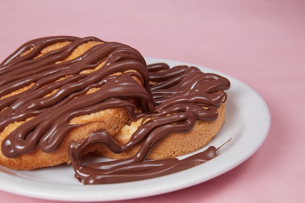 Fresh pancake in a plate poured with chocolate paste, cream on\
buns, pancakes with chocolate