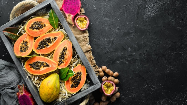 Fresh papaya on a black stone background Tropical Fruits Top view Free space for text