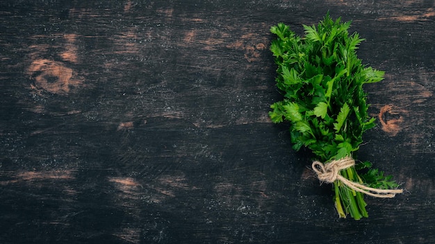 Fresh parsley on a black wooden background top view copy\
space