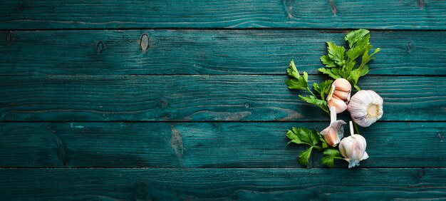 Photo fresh parsley and garlic on a dark background vegetables top view free space for your text