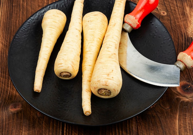 Photo fresh parsnip roots on wooden table