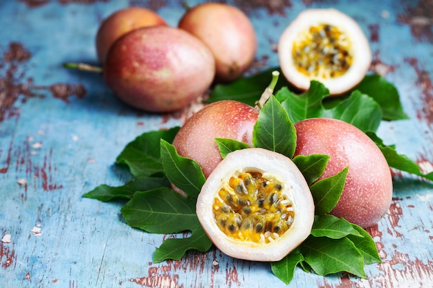 Fresh passion fruit with leaves on blue wooden background