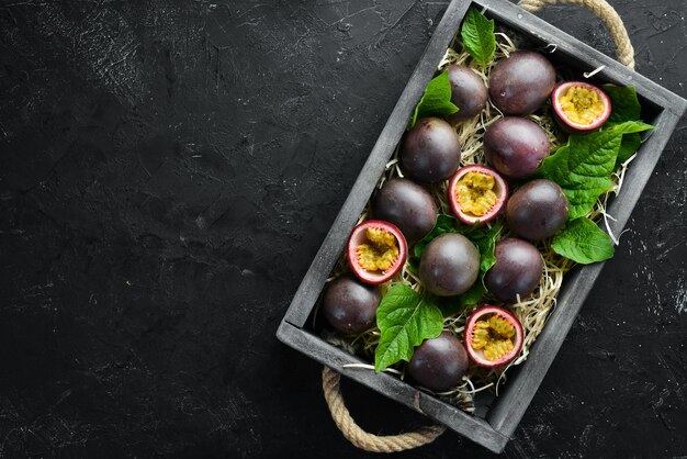 Fresh passion fruit with leaves in Wooden Box Tropical Fruits Top view Free space for text