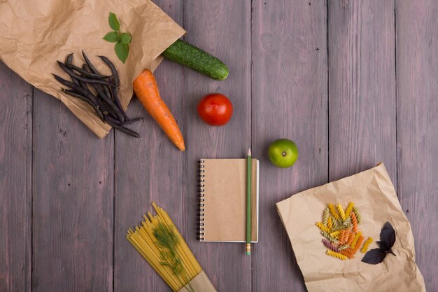 Ingredienti della pasta fresca in sacchetti di carta ecologici spaghetti pasta carota basilico pomodoro e altre verdure