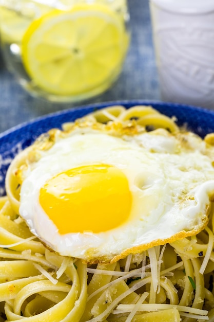 Fresh pasta pangrattato with crispy eggs on the table