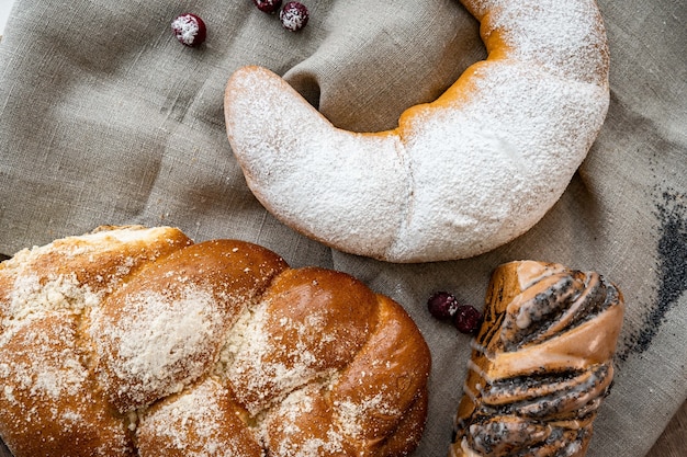 Fresh pastries buns in rustic style bakery on wooden table