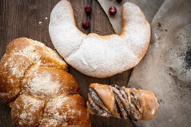 Fresh pastries buns in rustic style bakery on wooden table