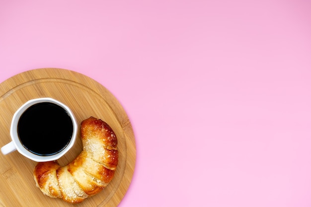 ピンクの背景に焼きたてのペストリーとコーヒートップビュー朝食のコンセプト