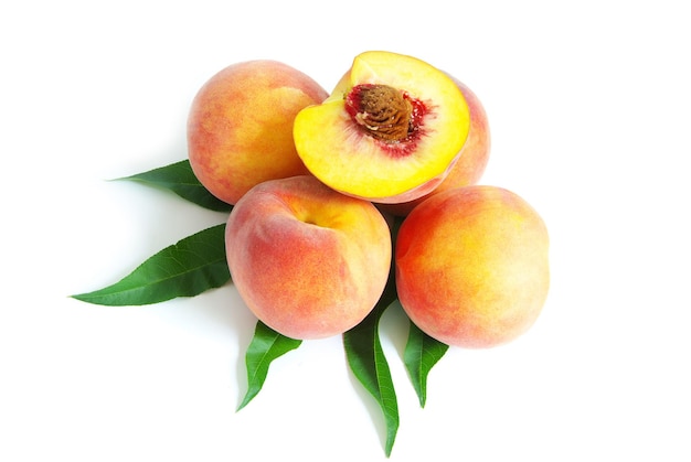 Fresh peach fruits with green leaves isolated on white