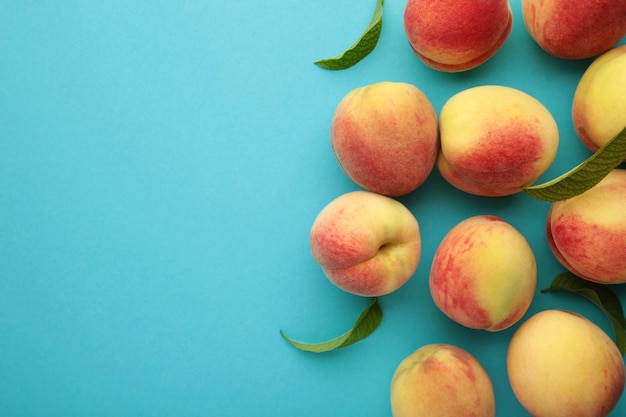 Fresh peaches on a blue background Space for text