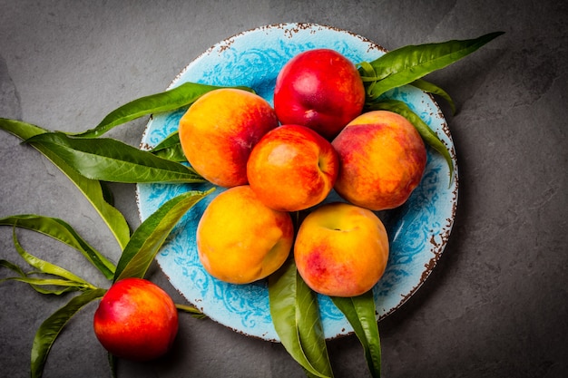Fresh peaches on a blue plate