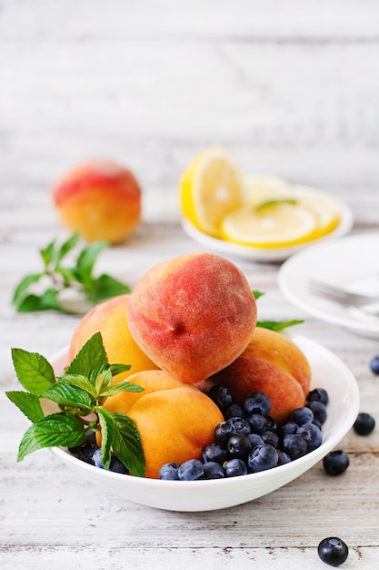 Fresh peaches and blueberries in bowl  wooden  in rustic style