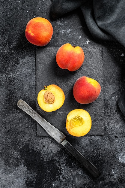 Fresh peaches on dark stone table
