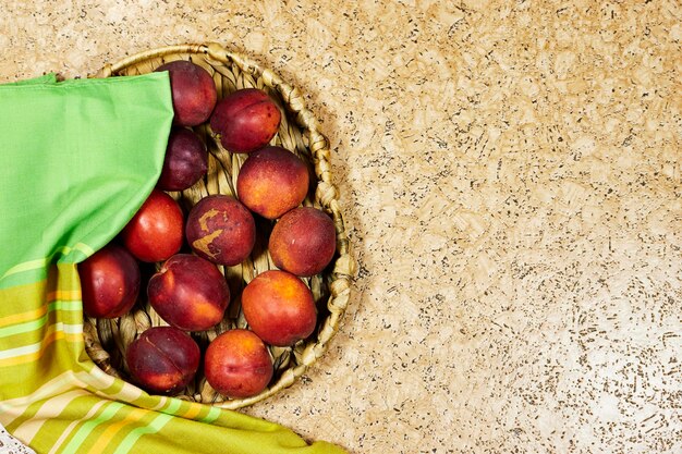 Photo fresh peaches in esparto halfah plate on wooden table